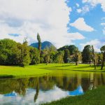 Panoramic view of a lush green golf course at Highland Golf Course. Smooth