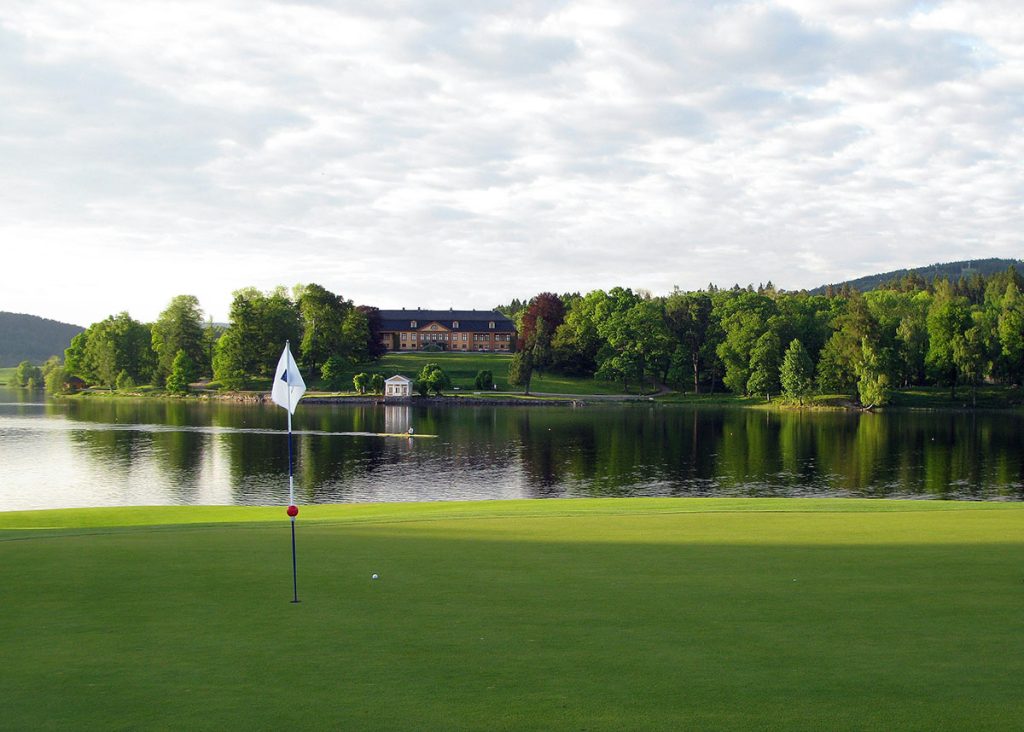 Panoramic view of a lush green golf course at Quail Creek Resort. Smooth