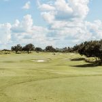 Panoramic view of a lush green golf course at Silver Springs Country Club. Smooth