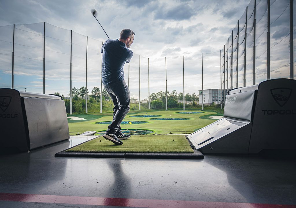 Panoramic view of a lush green golf course at Topgolf Birmingham. Smooth