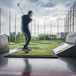 Panoramic view of a lush green golf course at Topgolf Birmingham. Smooth