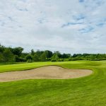 Panoramic view of a lush green golf course at Whippoorwill Golf Course. Smooth