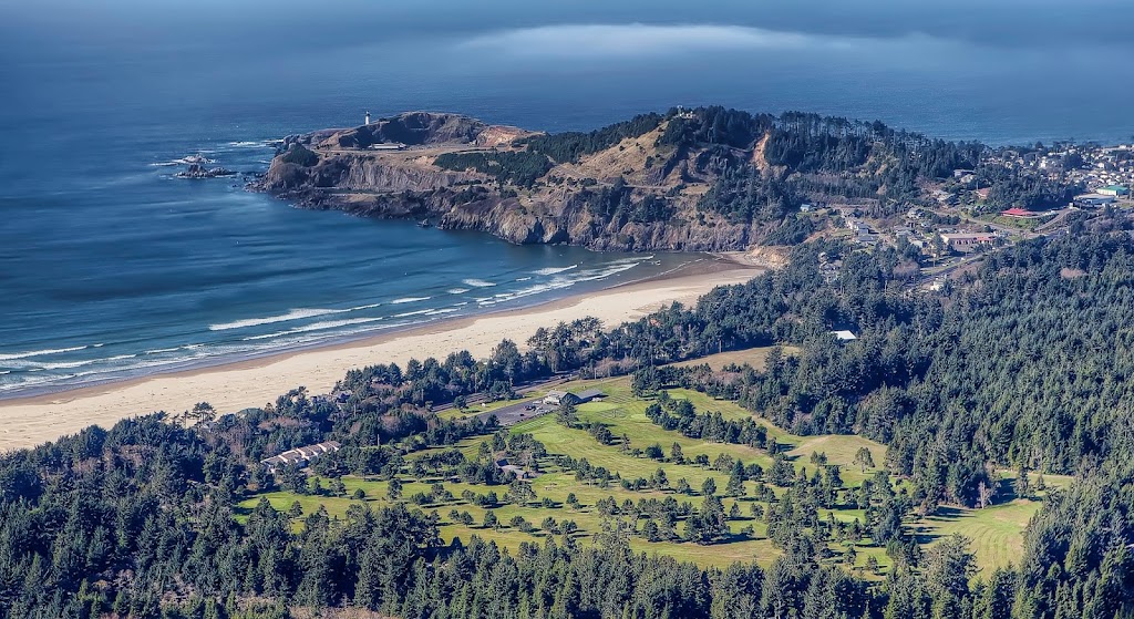 Panoramic view of a lush green golf course at Agate Beach Golf Course. Smooth