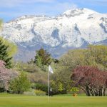 Panoramic view of a lush green golf course at Alpine Country Club. Smooth