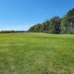 Panoramic view of a lush green golf course at Arrowhead Golf Course. Smooth