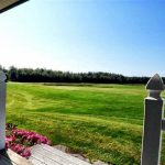 Panoramic view of a lush green golf course at Arrowhead Golf Course & Driving Range. Smooth