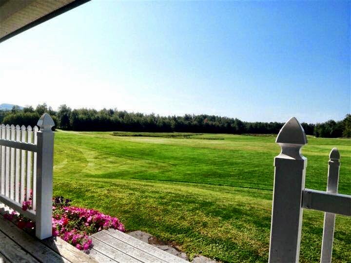 Panoramic view of a lush green golf course at Arrowhead Golf Course & Driving Range. Smooth