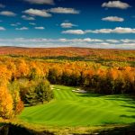 Panoramic view of a lush green golf course at Arthur Hills Golf Course. Smooth