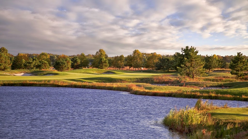 Panoramic view of a lush green golf course at Bear Trap Dunes. Smooth