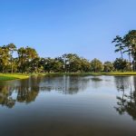 Panoramic view of a lush green golf course at Beau Chene Country Club. Smooth