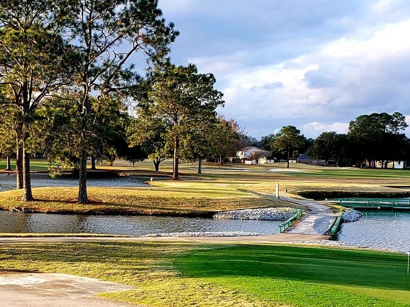 Panoramic view of a lush green golf course at Belle Terre Country Club. Smooth