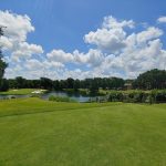 Panoramic view of a lush green golf course at Bent Tree Country Club. Smooth