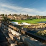 Panoramic view of a lush green golf course at Brasada Canyons. Smooth