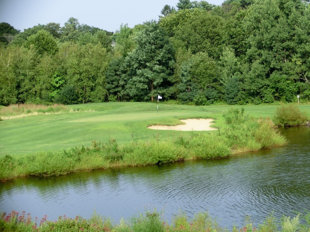 Panoramic view of a lush green golf course at Button Hole. Smooth