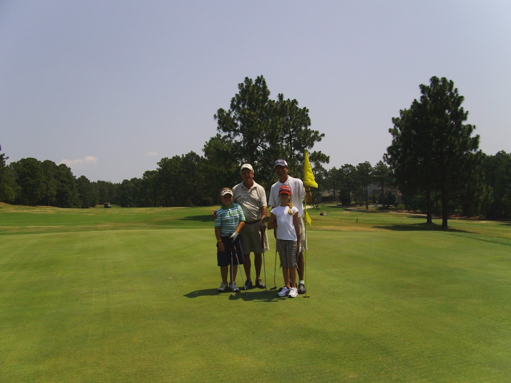 Panoramic view of a lush green golf course at Carolina Lakes Golf Course. Smooth