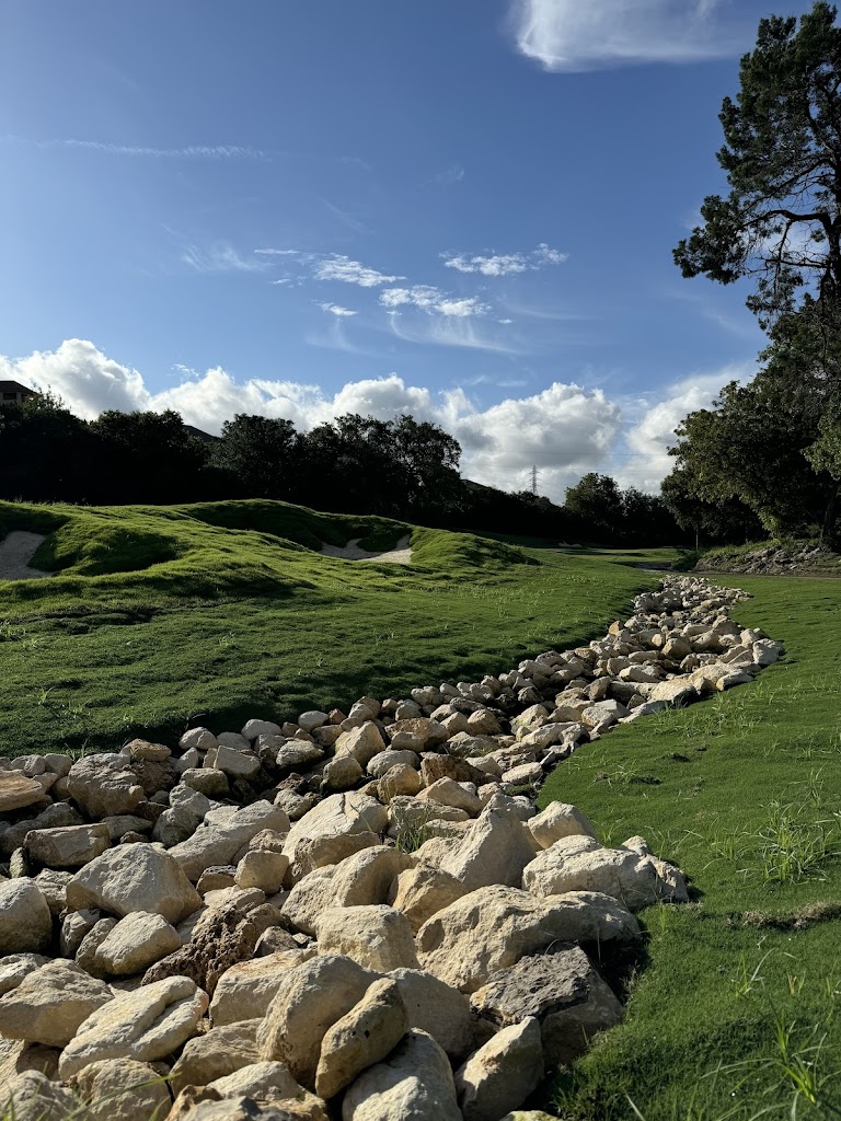 Panoramic view of a lush green golf course at Cedar Creek Golf Course. Smooth