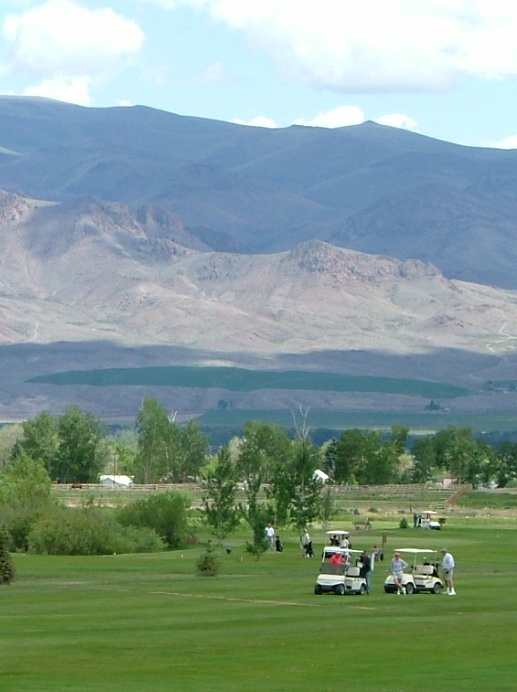 Panoramic view of a lush green golf course at Challis Golf Course. Smooth