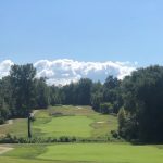 Panoramic view of a lush green golf course at Compass Pointe Golf Courses. Smooth