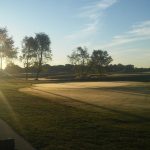 Panoramic view of a lush green golf course at Coyote Creek Golf Club. Smooth