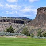 Panoramic view of a lush green golf course at Crooked River Ranch Golf Course. Smooth