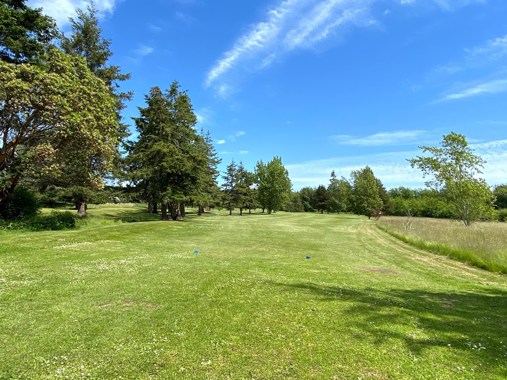 Panoramic view of a lush green golf course at Deception Pass Golf Center. Smooth