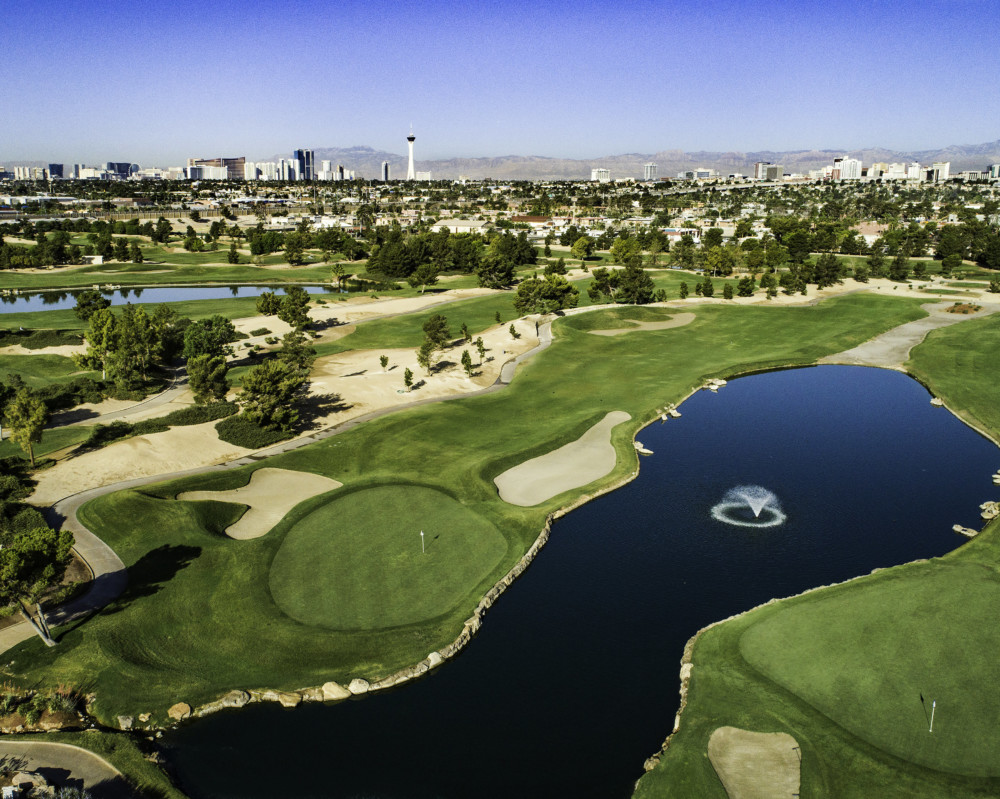 Panoramic view of a lush green golf course at Desert Pines Golf Club. Smooth