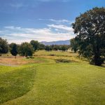 Panoramic view of a lush green golf course at Dutcher Creek Golf Course. Smooth