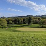 Panoramic view of a lush green golf course at Hidden Valley Country Club. Smooth