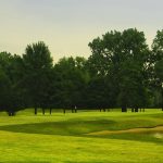 Panoramic view of a lush green golf course at Indian Boundary Golf Course. Smooth