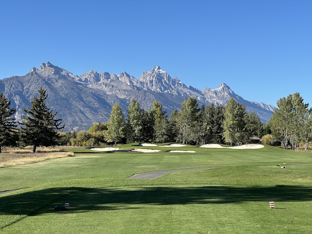 Panoramic view of a lush green golf course at Jackson Hole Golf & Tennis Club. Smooth