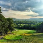 Panoramic view of a lush green golf course at Lake Winnipesaukee Golf Club. Smooth