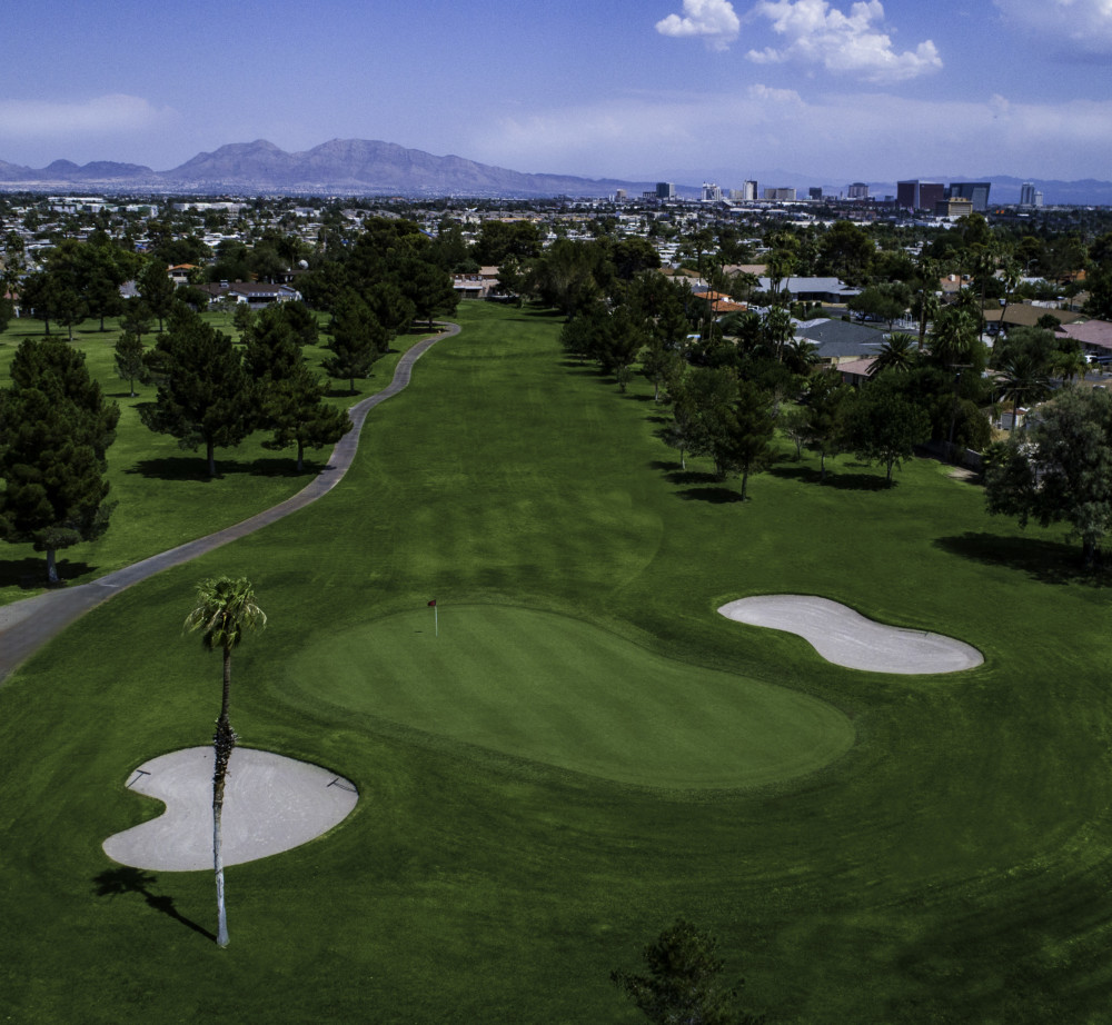 Panoramic view of a lush green golf course at Las Vegas Golf Club. Smooth