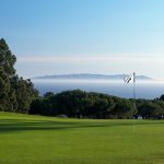 Panoramic view of a lush green golf course at Los Verdes Golf Course. Smooth