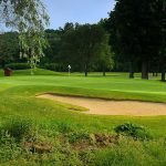 Panoramic view of a lush green golf course at Lyman Orchards Golf Club. Smooth