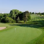 Panoramic view of a lush green golf course at Manhattan Country Club. Smooth