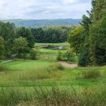 Panoramic view of a lush green golf course at Manitou Passage Golf Club. Smooth