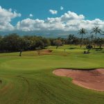 Panoramic view of a lush green golf course at Maui Nui Golf Club. Smooth