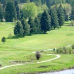 Panoramic view of a lush green golf course at Mirror Lake Golf Course. Smooth