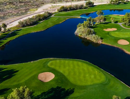 Panoramic view of a lush green golf course at Mojave Resort Golf Club. Smooth