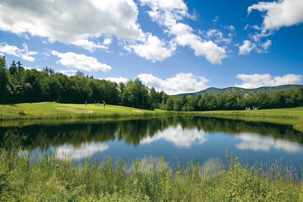 Panoramic view of a lush green golf course at Mount Snow Golf Club. Smooth