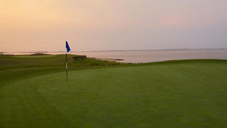 Panoramic view of a lush green golf course at Nags Head Golf Links. Smooth