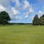 Panoramic view of a lush green golf course at North Hill Country Club. Smooth