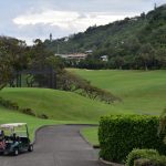 Panoramic view of a lush green golf course at Oahu Country Club. Smooth