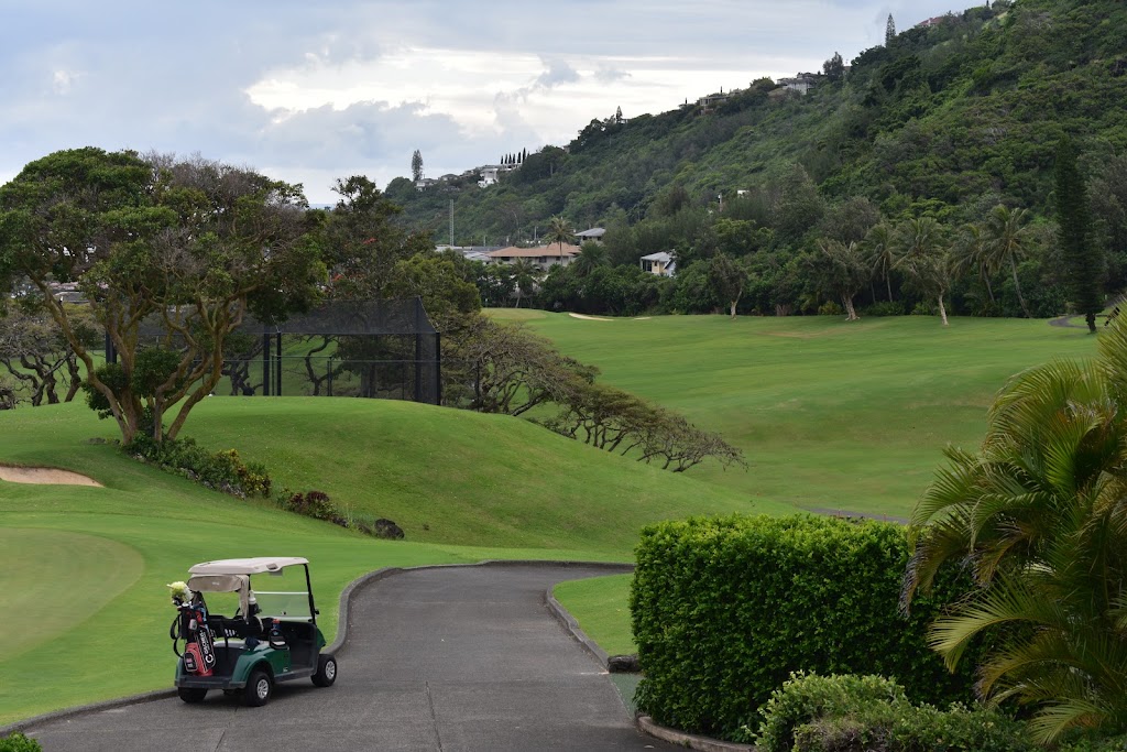 Panoramic view of a lush green golf course at Oahu Country Club. Smooth