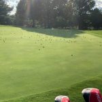 Panoramic view of a lush green golf course at Oak Hills Golf Center. Smooth