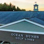 Panoramic view of a lush green golf course at Ocean Dunes Golf Links. Smooth