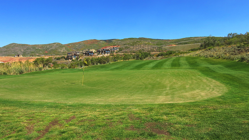 Panoramic view of a lush green golf course at Outlaw Golf Club. Smooth