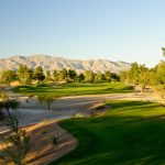 Panoramic view of a lush green golf course at Painted Desert Golf Club. Smooth