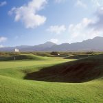 Panoramic view of a lush green golf course at Painted Dunes Desert Golf Course. Smooth