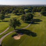 Panoramic view of a lush green golf course at Painted Hills Golf Course. Smooth